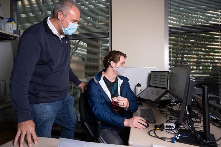 <p>Associate Professor Omer Inan and Ph.D. student John Berkebile look over some research.</p>