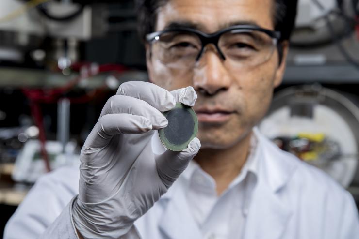 <p>Principal investigator Meilin Liu holds up an example of the new, practical, affordable fuel cell in his lab at the Georgia Institute of Technology. Credit: Georgia Tech / Christopher Moore</p>