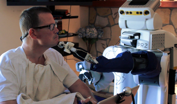 <p>Robotic body surrogates can help people with profound motor deficits interact with the world. Here, Henry Evans, a California man who helped Georgia Tech researchers with improvements to a web-based interface, uses the robot to shave himself. (Credit: Henry Clever/Phillip Grice, Georgia Tech)</p>