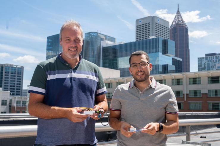 Samer Mabrouk and Omer Inan hold prototypes of their device.