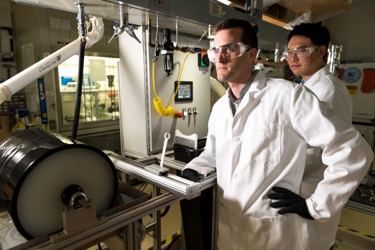 <p>Georgia Tech Assistant Professor Ryan Lively (left) and Postdoctoral Fellow Dong-Yeun Koh monitor the spinning process used to produce the polymeric fibers that are converted for use in the carbon membranes used for separating alkyl aromatic chemicals. (Credit: Rob Felt, Georgia Tech)</p>