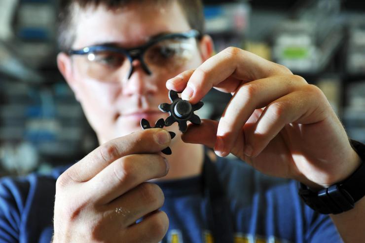 <p>Georgia Tech Graduate Student Caleb Amy shows how two ceramic gears mesh in a pump developed to transfer molten tin at more than 1,400 degrees Celsius. (Credit: Christopher Moore, Georgia Tech)</p>