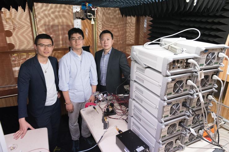 <p>Georgia Tech researchers are shown with electronics equipment and antenna setup used to measure far-field radiated output signal from millimeter wave transmitters. Shown are Graduate Research Assistant Huy Thong Nguyen, Graduate Research Assistant Sensen Li, and Assistant Professor Hua Wang. (Credit: Allison Carter, Georgia Tech)</p>