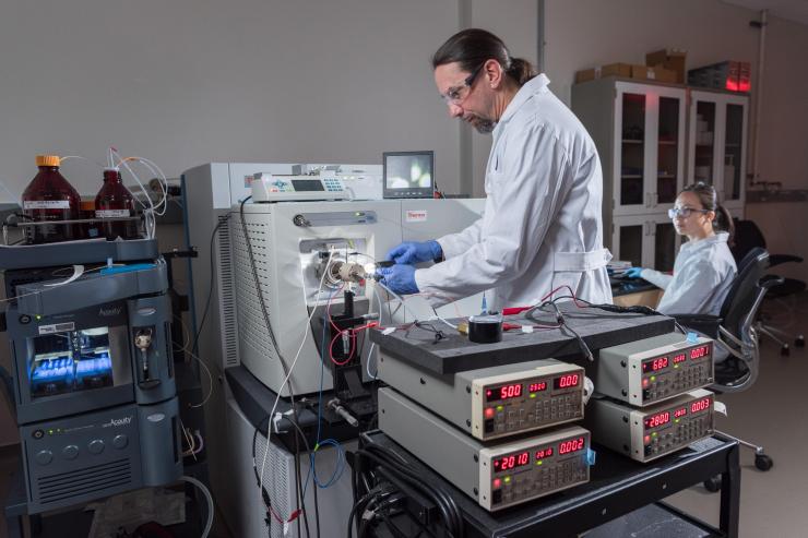 <p>Research Scientist Alex Jonke (left) connects DRILL to a mass spectrometer in the Torres laboratory at Georgia Tech, while Graduate Research Assistant Jung Lee prepares to collect mass spectra resulting from the analysis. (Credit: Rob Felt, Georgia Tech)</p>