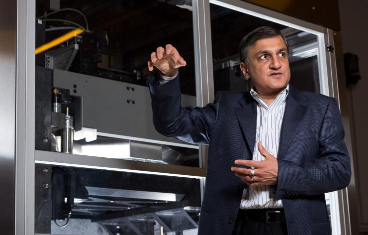 <p>Suman Das, Morris M. Bryan, Jr. Chair in Mechanical Engineering for Advanced Manufacturing Systems and Professor, stands in front of the LAMP System CPT6060, which makes ceramic cores and molds used in making aircraft parts.</p>