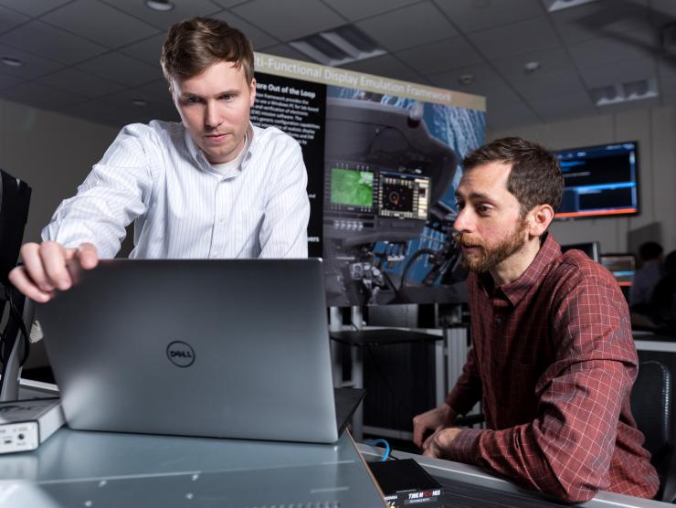 <p>GTRI researchers and the Army Reprogramming Analysis Team have developed an MFD/MPD emulator that allows software updates for the UH60M Blackhawk and AH64D Apache helicopters to be tested in the laboratory. Shown are (l-r) are GTRI Research Scientists Heyward Adams and Brian Wells. (Credit: Rob Felt, Georgia Tech)</p>