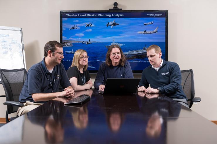 <p>GTRI researchers analyze the mission planning task. Shown are Senior Research Engineer John Huggins, Research Scientist Elizabeth Weldon, Research Engineer Jerry Ray and Research Scientist Stuart Michelson. (Credit: Rob Felt, Georgia Tech)</p>