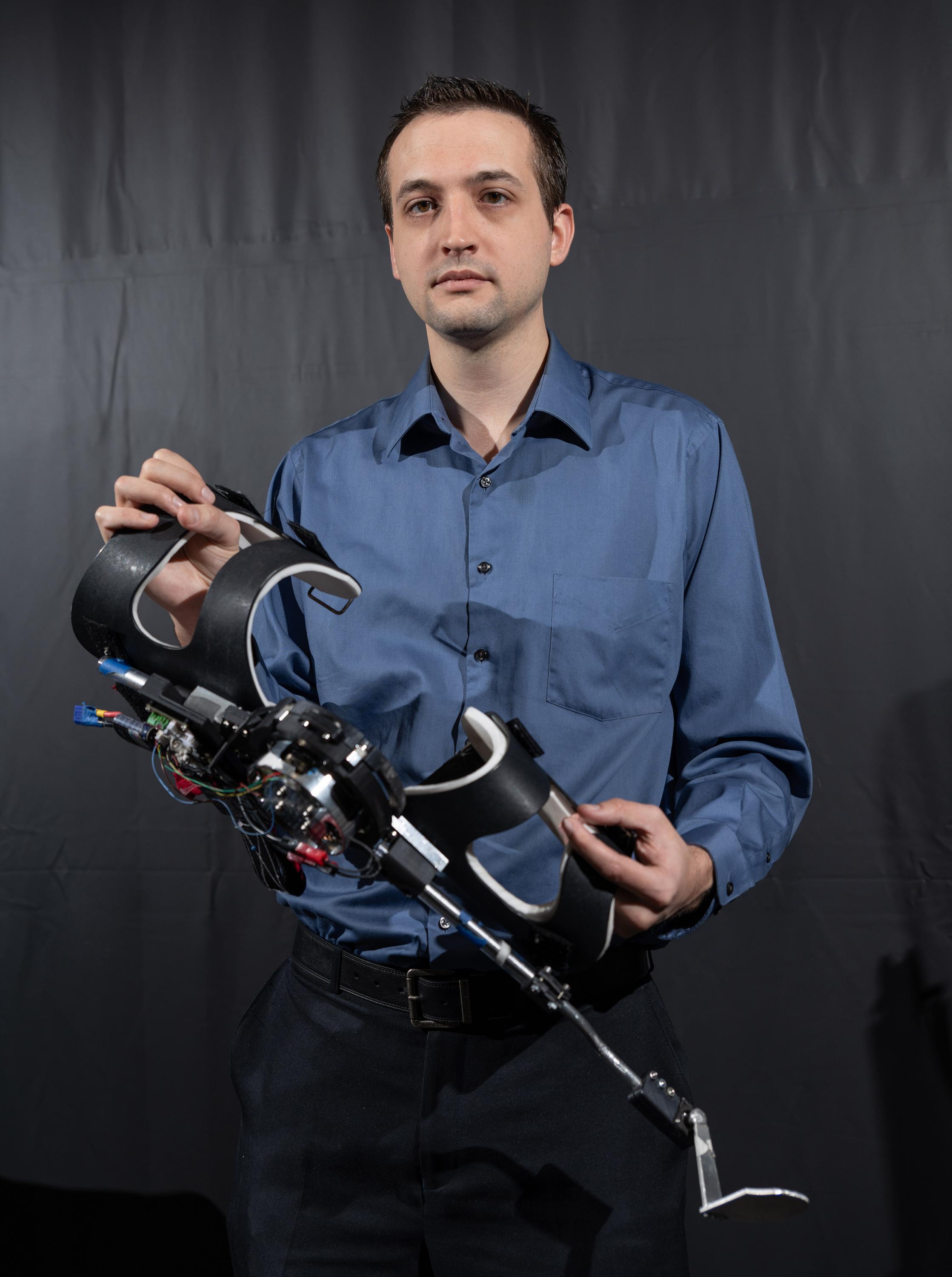 Georgia Tech Assistant Professor Aaron Young (with the pediatric knee exoskeleton) works with exoskeletons and powered orthoses to augment human performance. (Credit: Rob Felt, Georgia Tech)