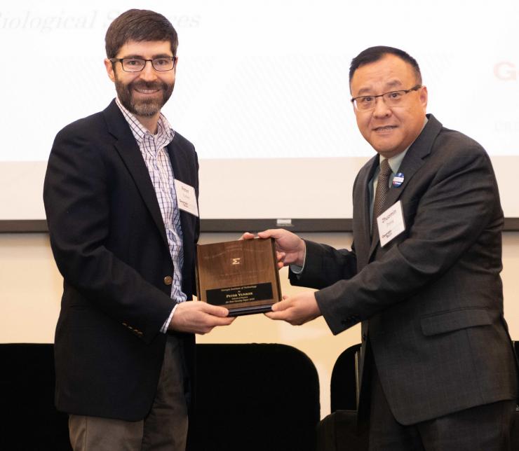 <p>Peter Yunker accepts his award from Mehanical Engineering Professor Zhuomin Zhang.</p>