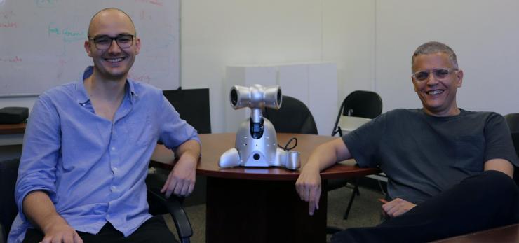 <p>Gil Weinberg and Richard Savery pose with a Shimi robot, one of the robots created by the Robotic Musicianship group.</p>