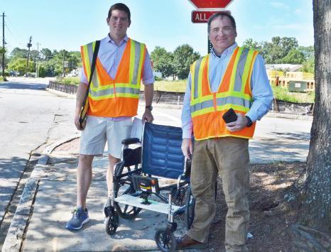 <p>GT Professor Randal Guensler and grad student Daniel Walls demonstrating their wheelchair based sidewalk survey rig.</p>