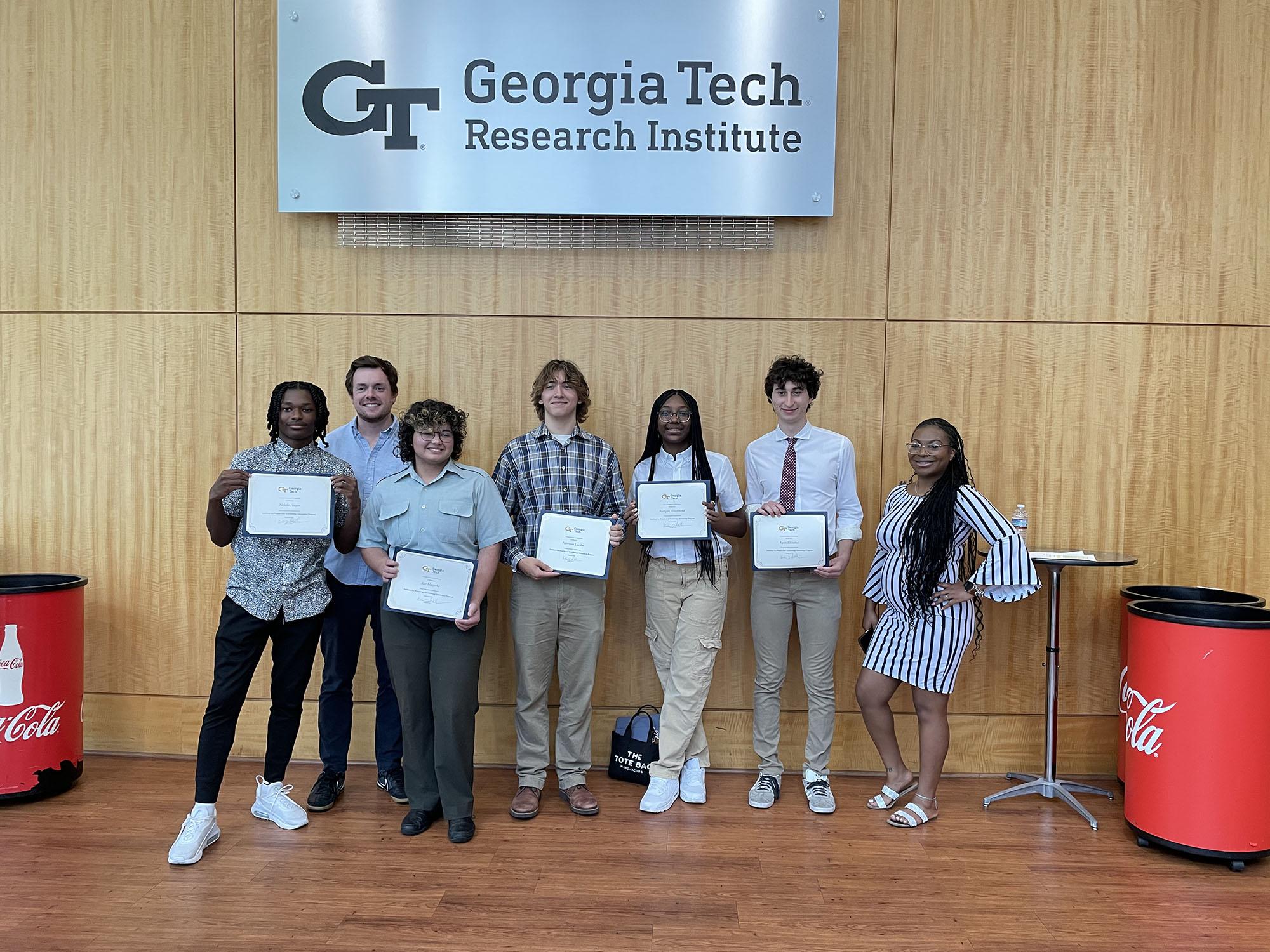 Students holding their internship completion certificates.