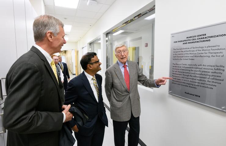 <p>A plaque is unveiled in the new Good Manufacturing Practice (GMP) like facility that is part of the Marcus Center for Therapeutic Cell Characterization and Manufacturing (MC3M). Shown are Georgia Tech President G.P. “Bud” Peterson, Center Director Krishnendu Roy, and philanthropist Bernie Marcus. (Credit: Rob Felt, Georgia Tech)</p>