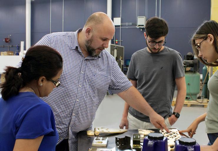 <p>Aaron Stebner (second from left), associate professor in the College of Engineering, leads a lab session with students in the Delta Air Lines Advanced Manufacturing Pilot Facility at Georgia Tech. (Photo: Christa M. Ernst)</p>