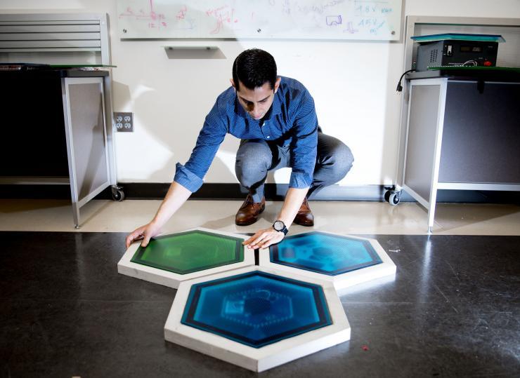 <p>Ilan Stern, a GTRI senior research scientist, shows piezoelectric tiles that will be used to create a lighted outdoor footpath at the NASA Kennedy Space Center’s Visitor Complex at Cape Canaveral, Florida. He’s holding the electronic components used in the tiles. (Credit: Branden Camp, Georgia Tech)</p>