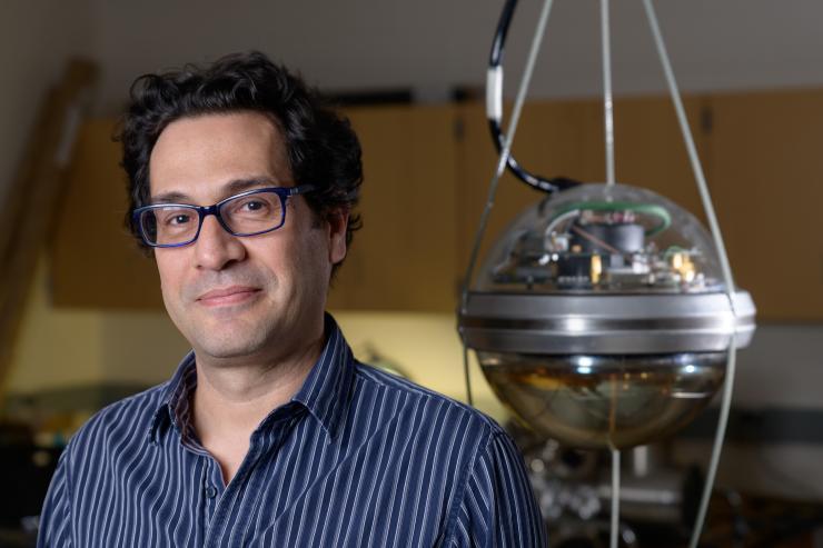 <p>Image shows Georgia Tech Associate Professor Ignacio Taboada with a digital optical module of the kind used in the IceCube Neutrino Observatory. The observatory has 5,000 of the modules suspended in clear ice to detect blue light indicating passage of a neutrino.(Credit: Rob Felt, Georgia Tech)</p>